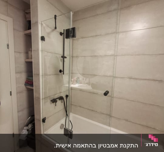 מקלחת עם דלת זכוכית וברזים שחורים
